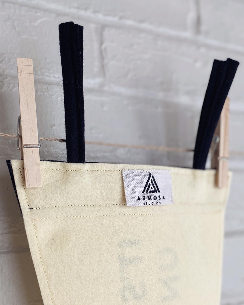 the back of a cream and black pennant showing the custom Armosa Studios logo