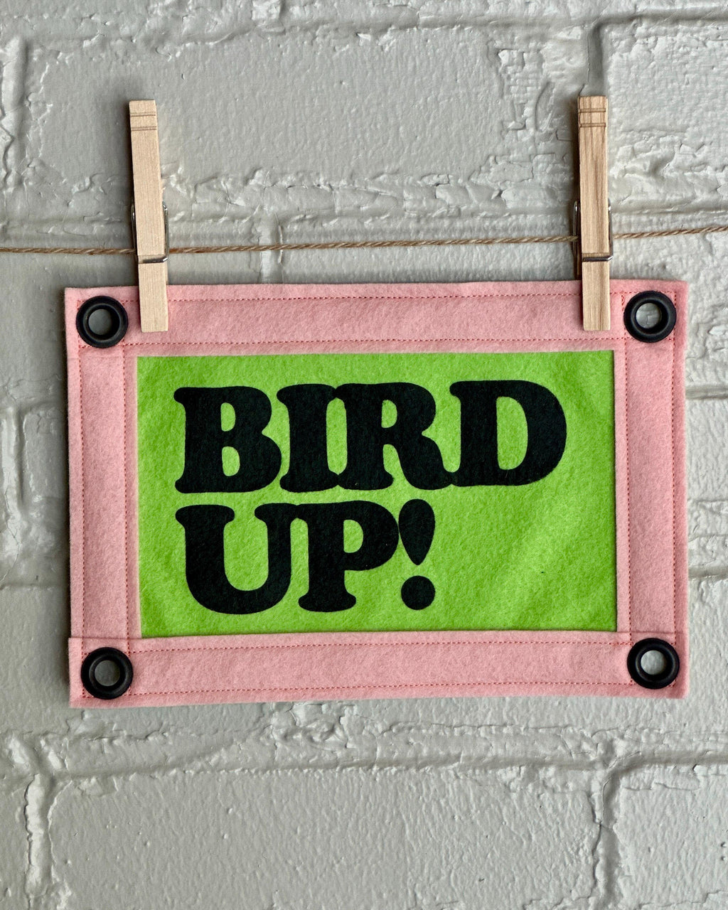 Bright green felt banner with light pink trim, and black lettering that reads "Bird up!"