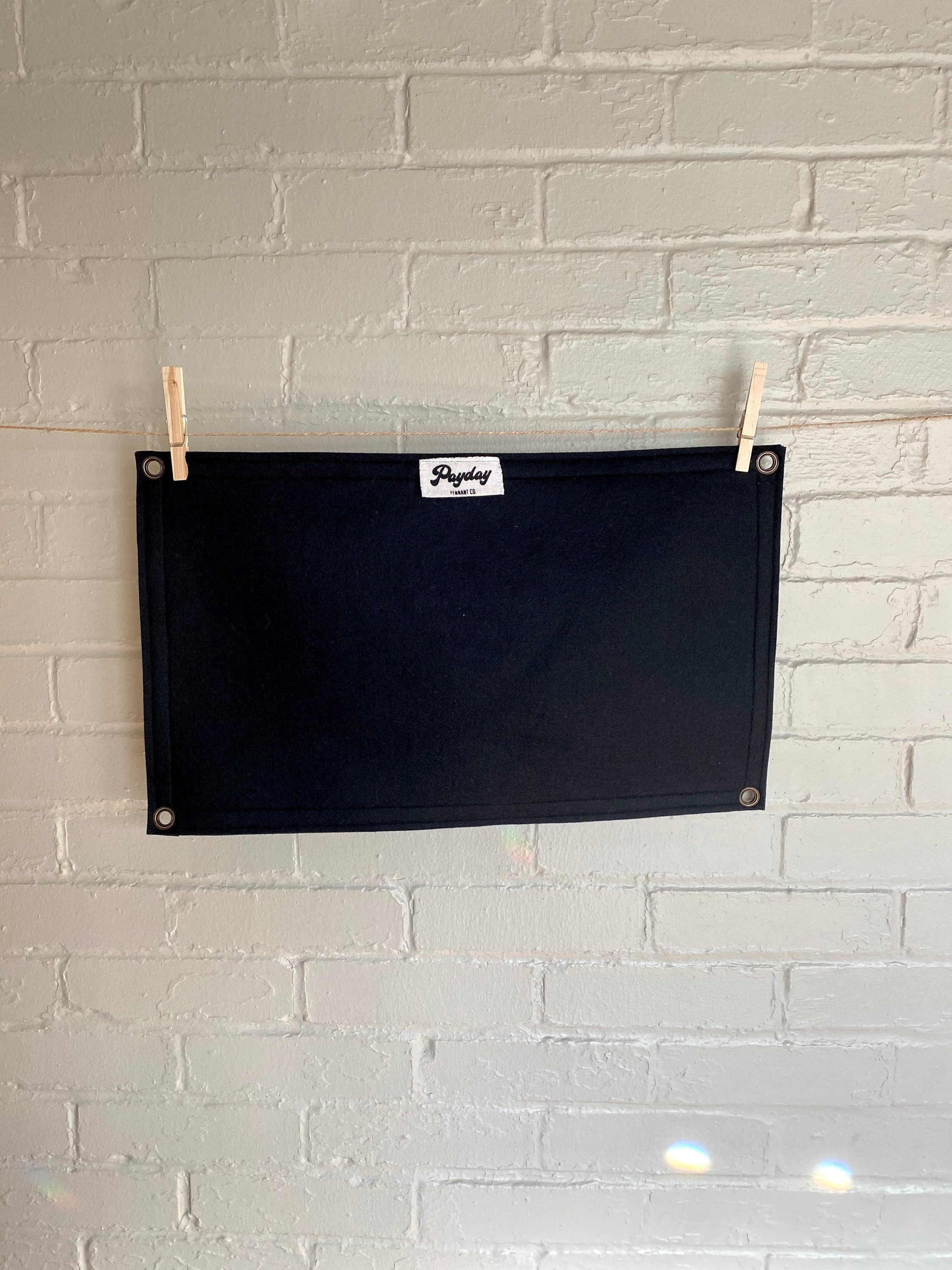 Back of a large black felt banner with a jolly roger boognish design printed in white ink