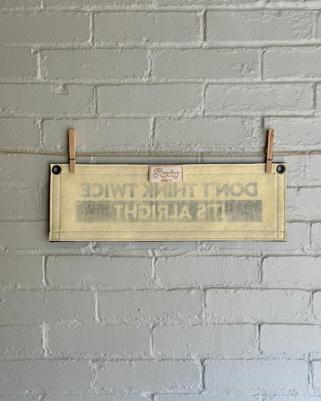 The back of a cream banner with black trim and lettering that reads "Don't Think Twice It's Alright"