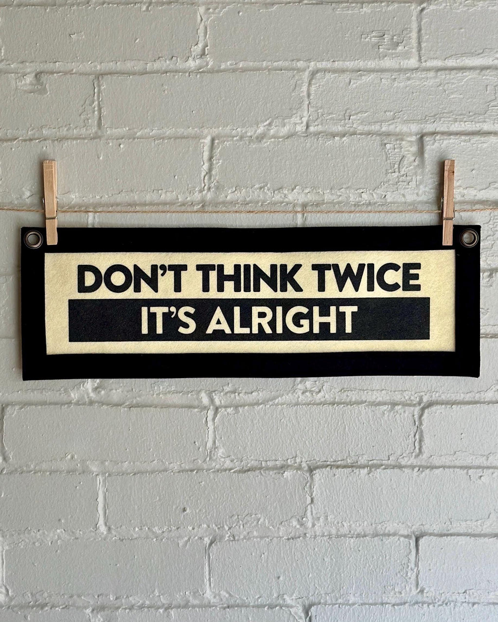 A cream banner with black trim and lettering that reads "Don't Think Twice It's Alright"