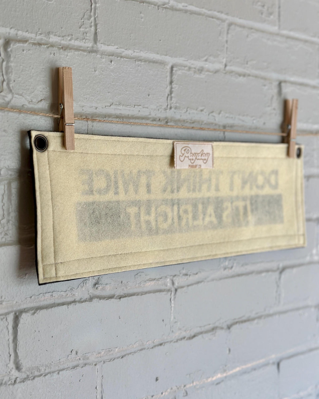 A back, side view of a cream banner with black trim and lettering that reads "Don't Think Twice It's Alright"