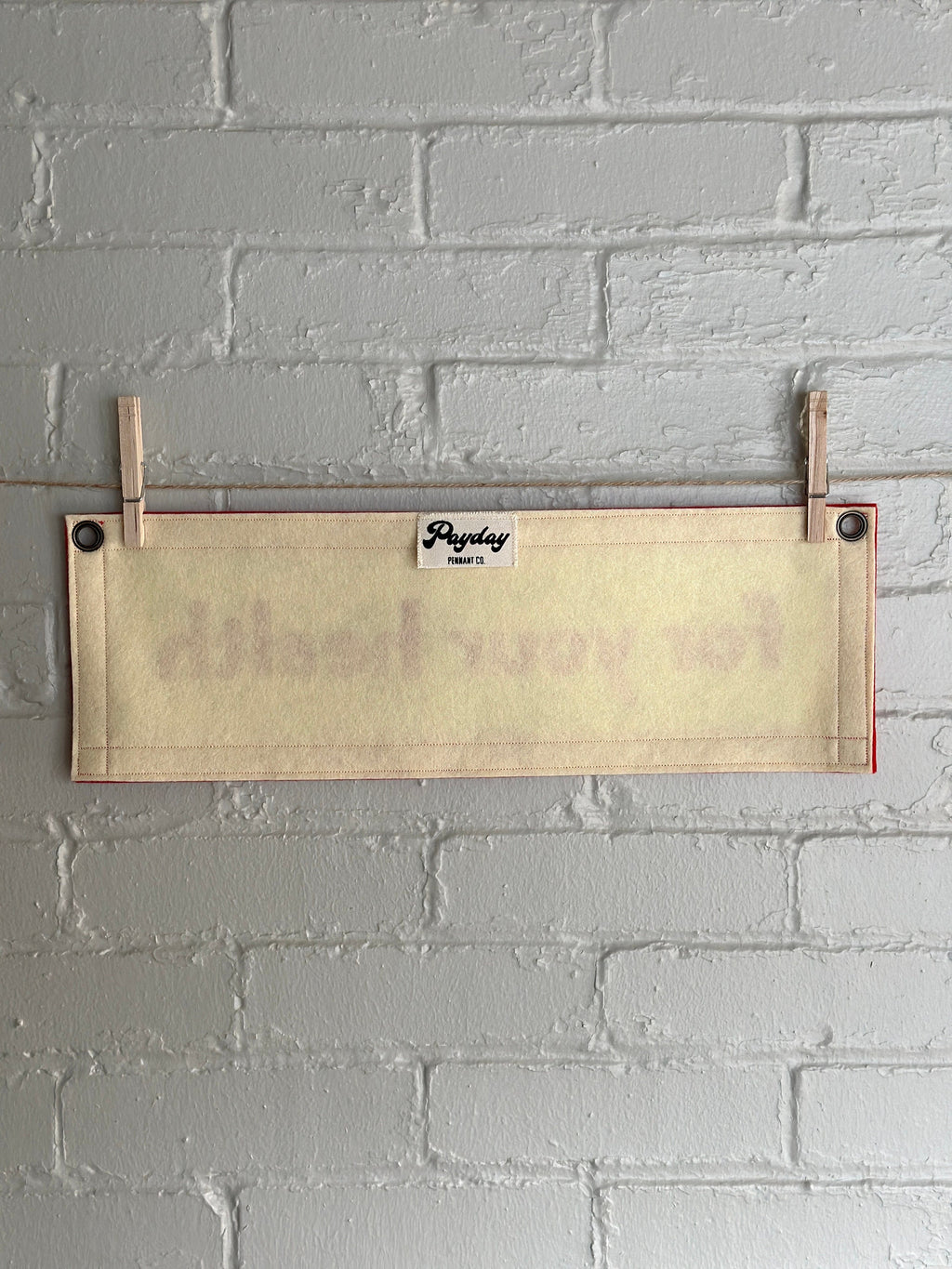 Back view of a cream banner with red felt trim and red lettering that reads "for your health"
