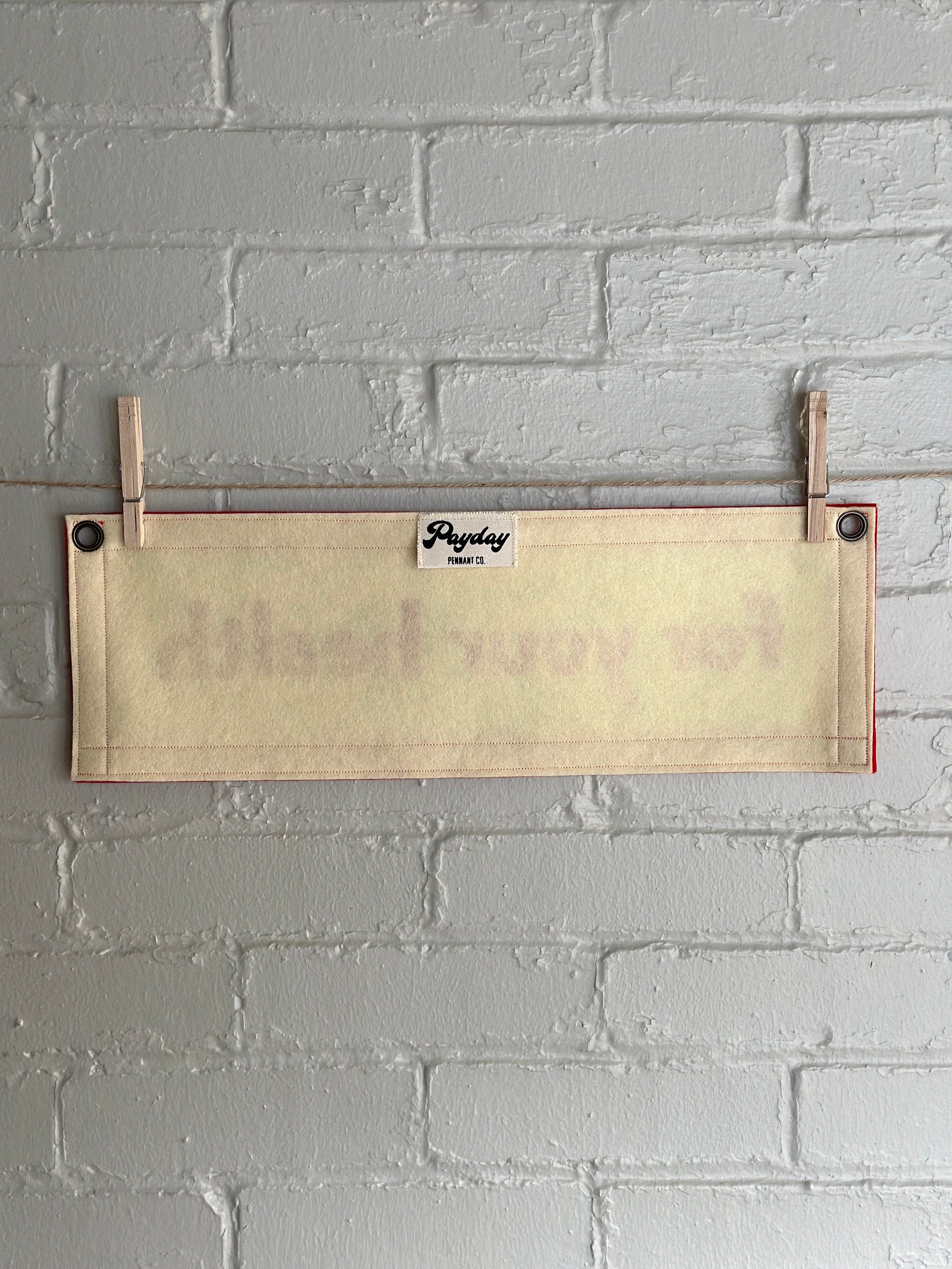 Back view of a cream banner with red felt trim and red lettering that reads "for your health"