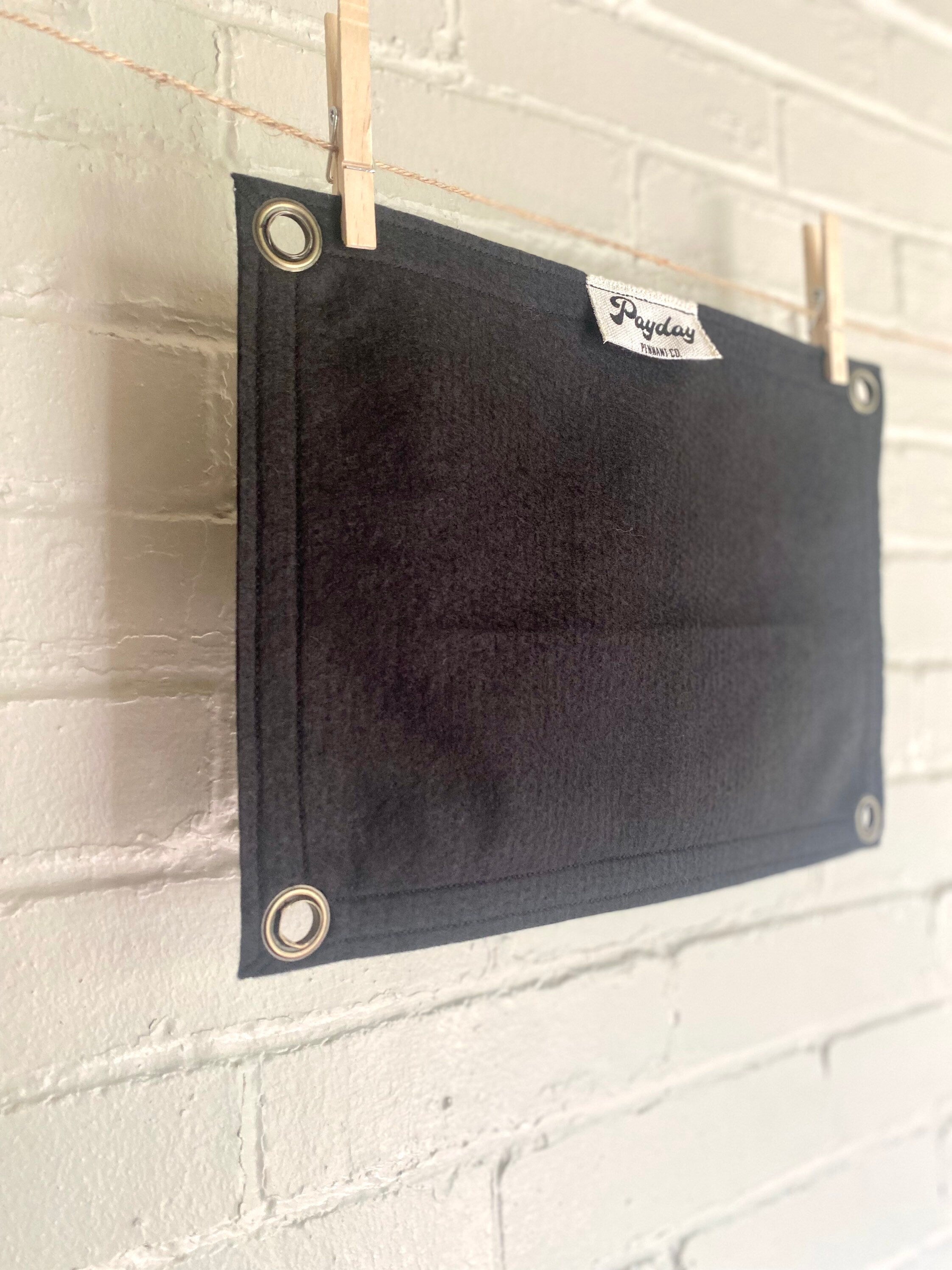 Side view of a black banner with black felt trim and white lettering that reads "the gang stays home"