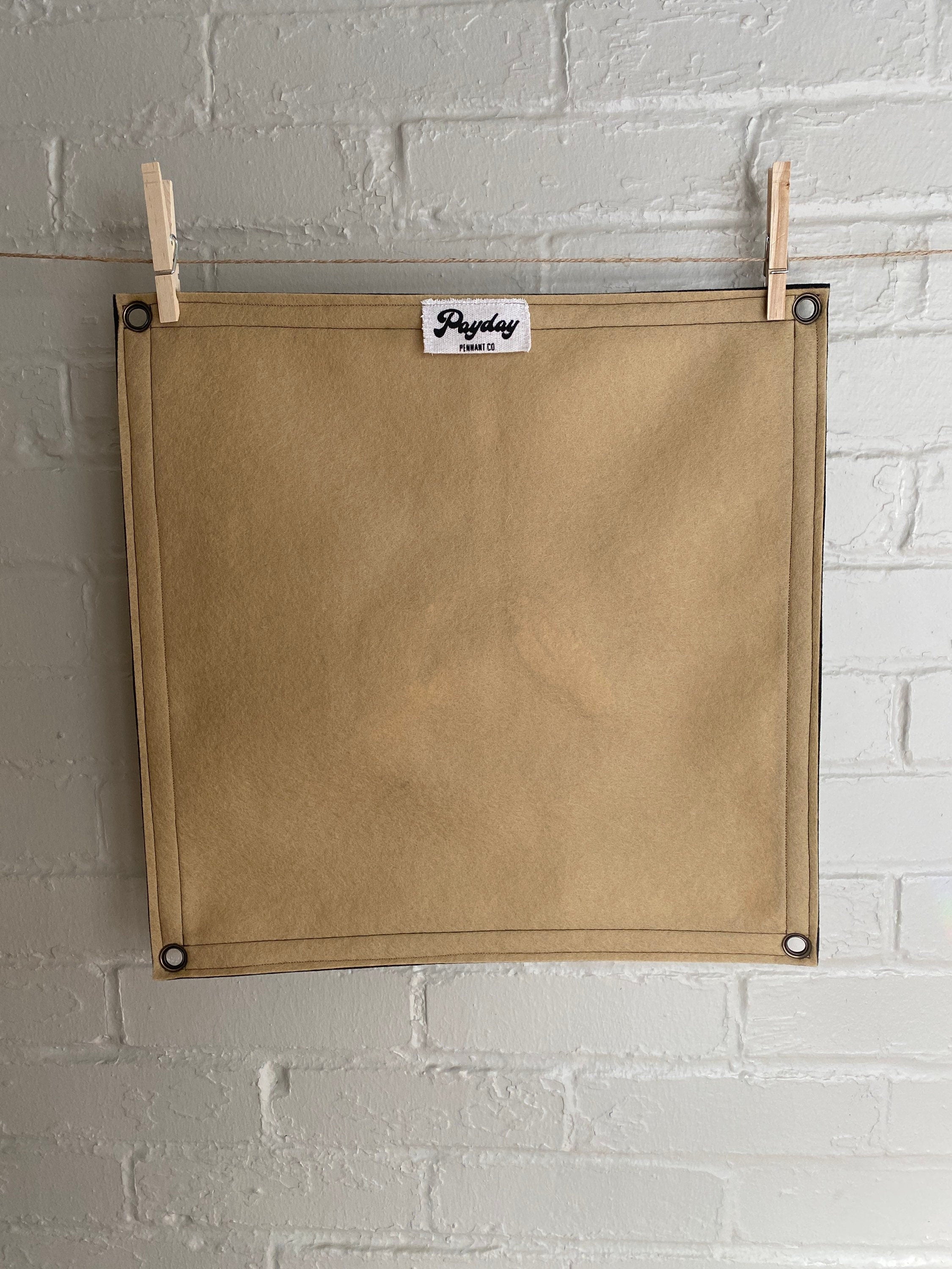 Backside view of a light brown felt banner with black trim, and album art from band Godspeed You! Black Emperor