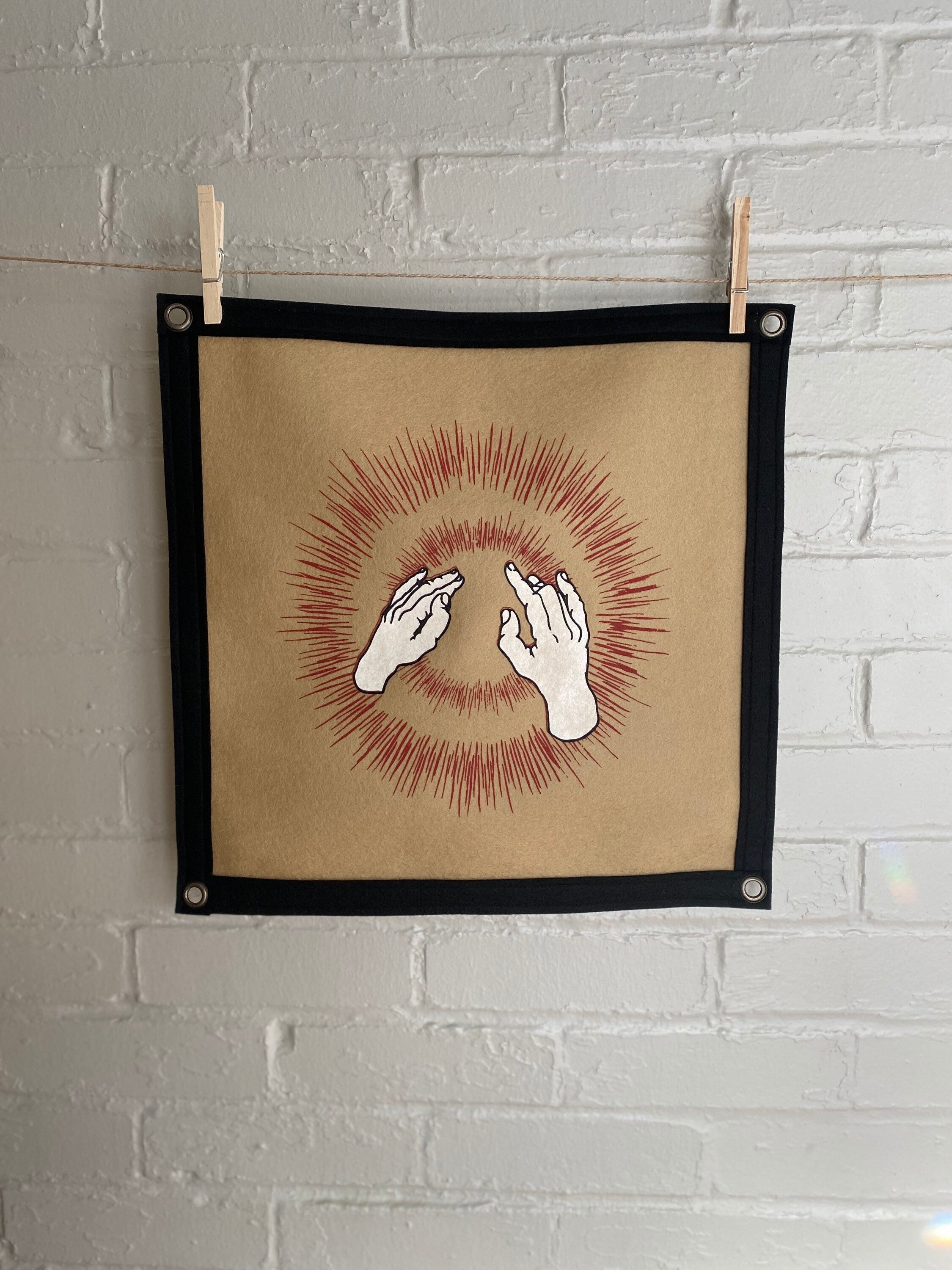 Light brown felt banner with black trim, and album art from band Godspeed You! Black Emperor