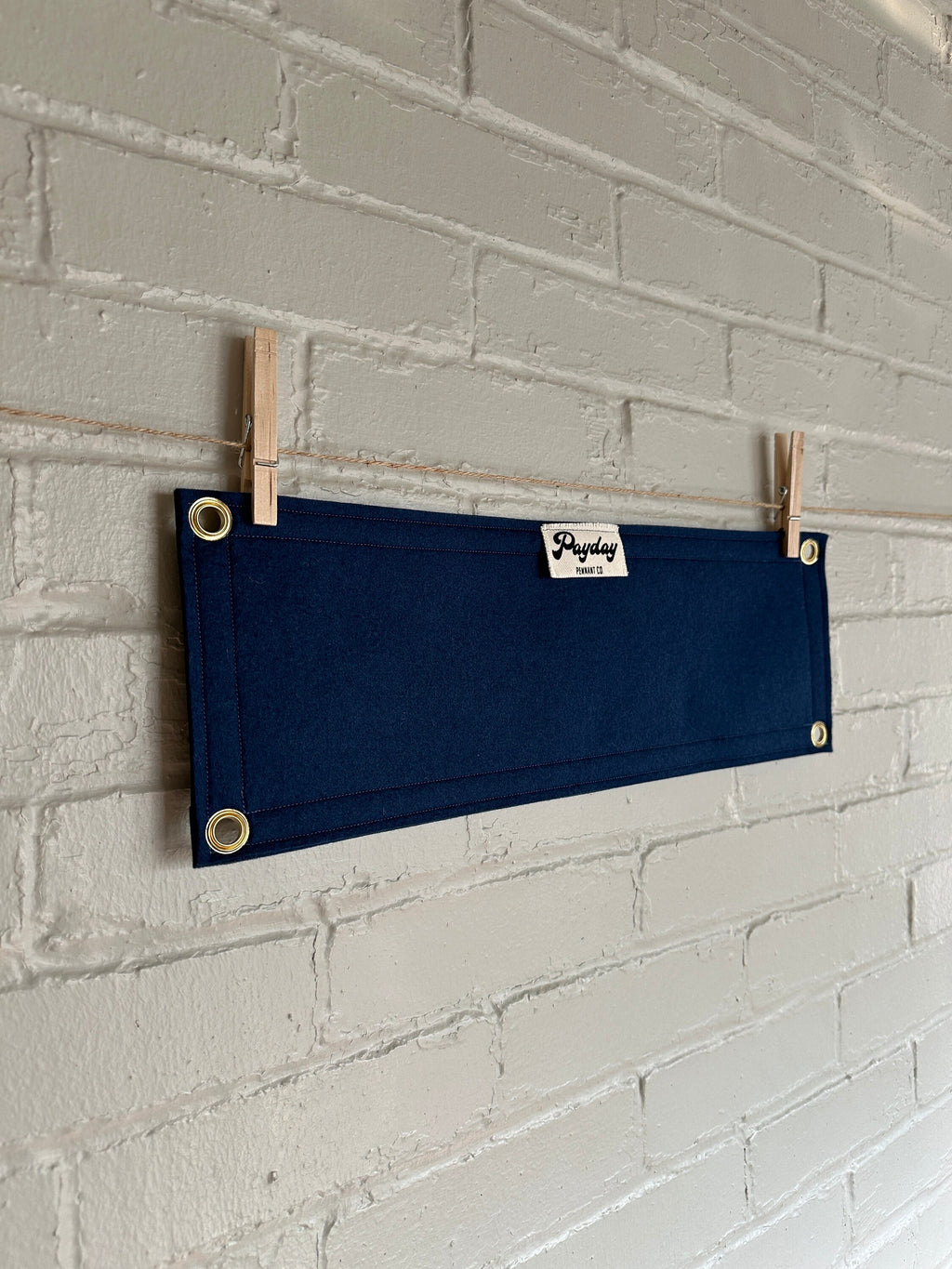 Back of a navy felt banner with navy trim and gold ink lettering that reads "MISBEHAVIN'"