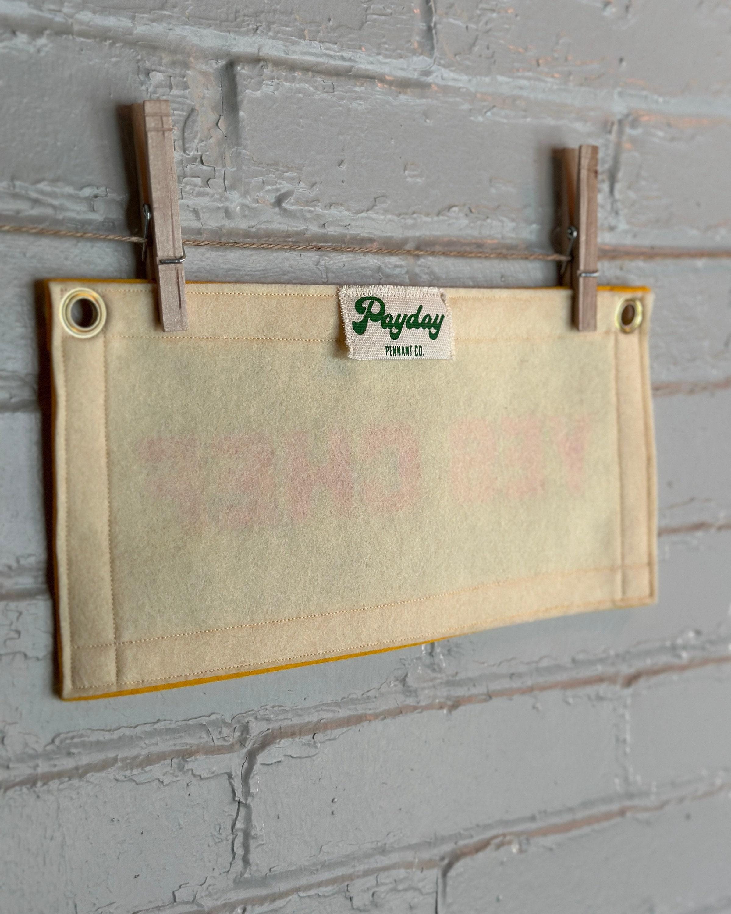 Back view of a cream felt banner with yellow trim and pink print reading "YES CHEF"