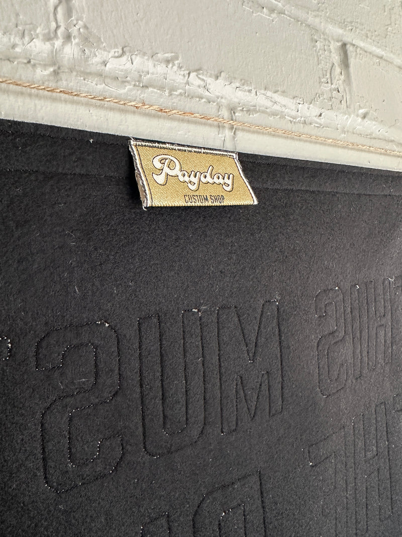 The back of a black banner with Payday Pennant Co. Custom Shop tag showing.