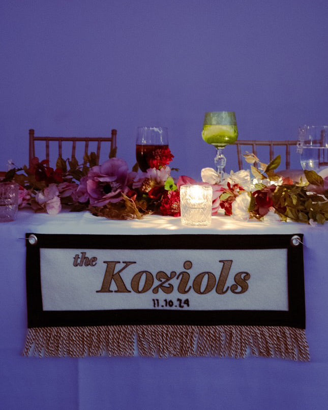 Wedding table with a banner that reads 'the Koziols' printed on it