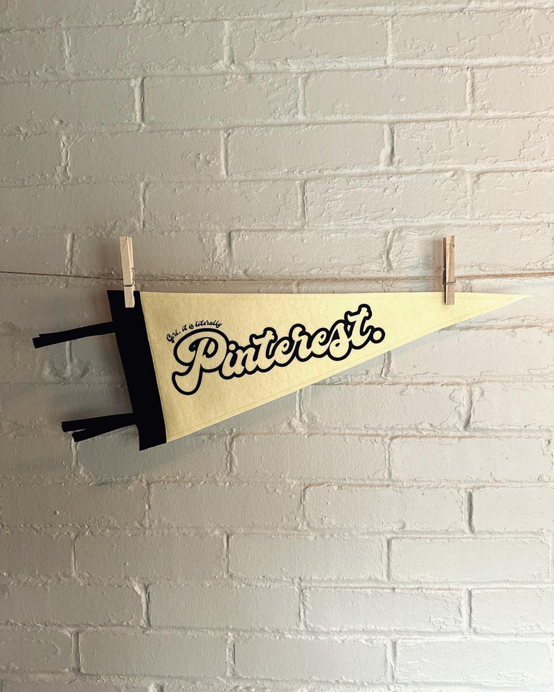A cream pennant with black trim and the words "Girl, it is literally Pinterest." printed in black ink.