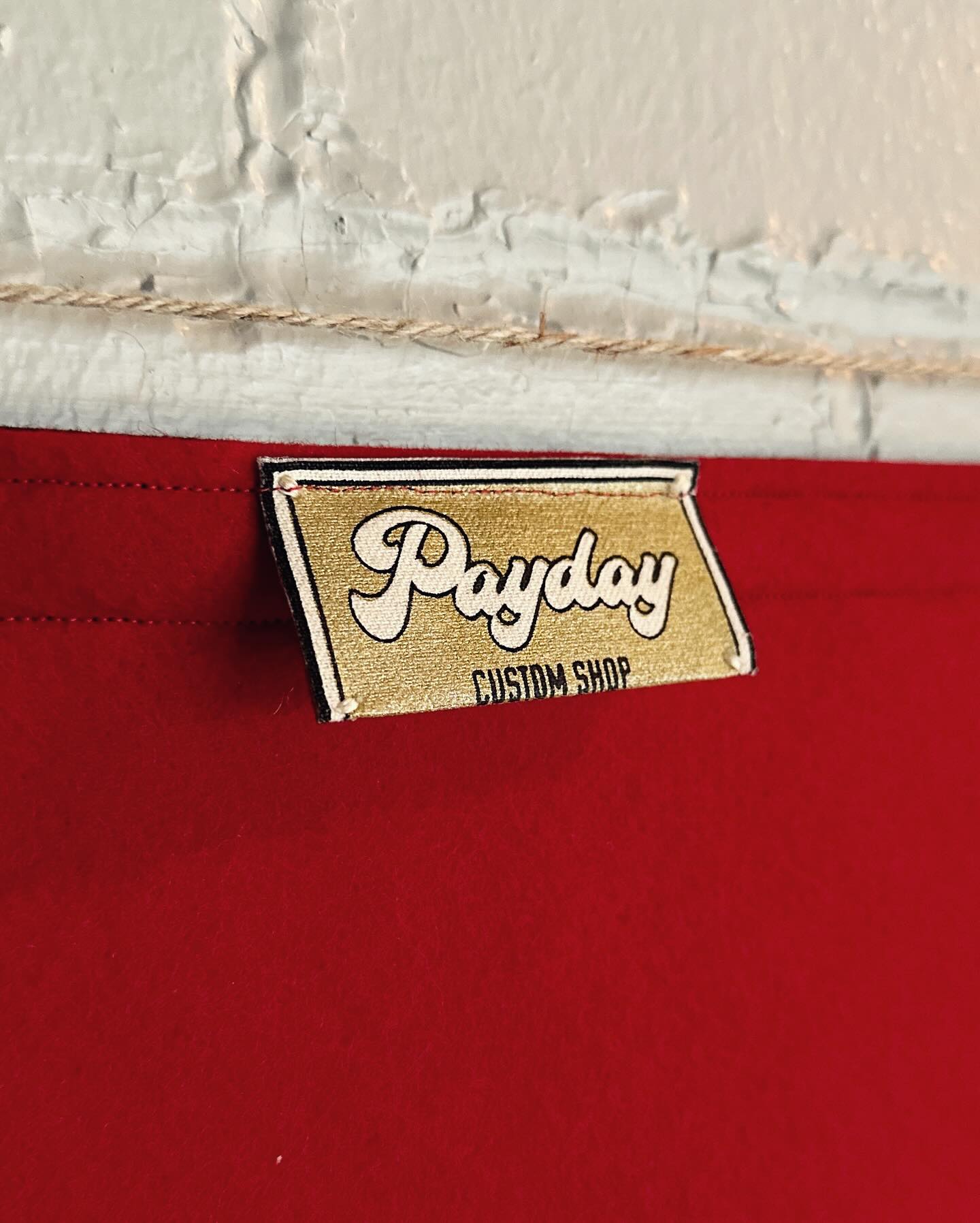 The back of a red felt banner with a Payday Custom Shop tag showing.