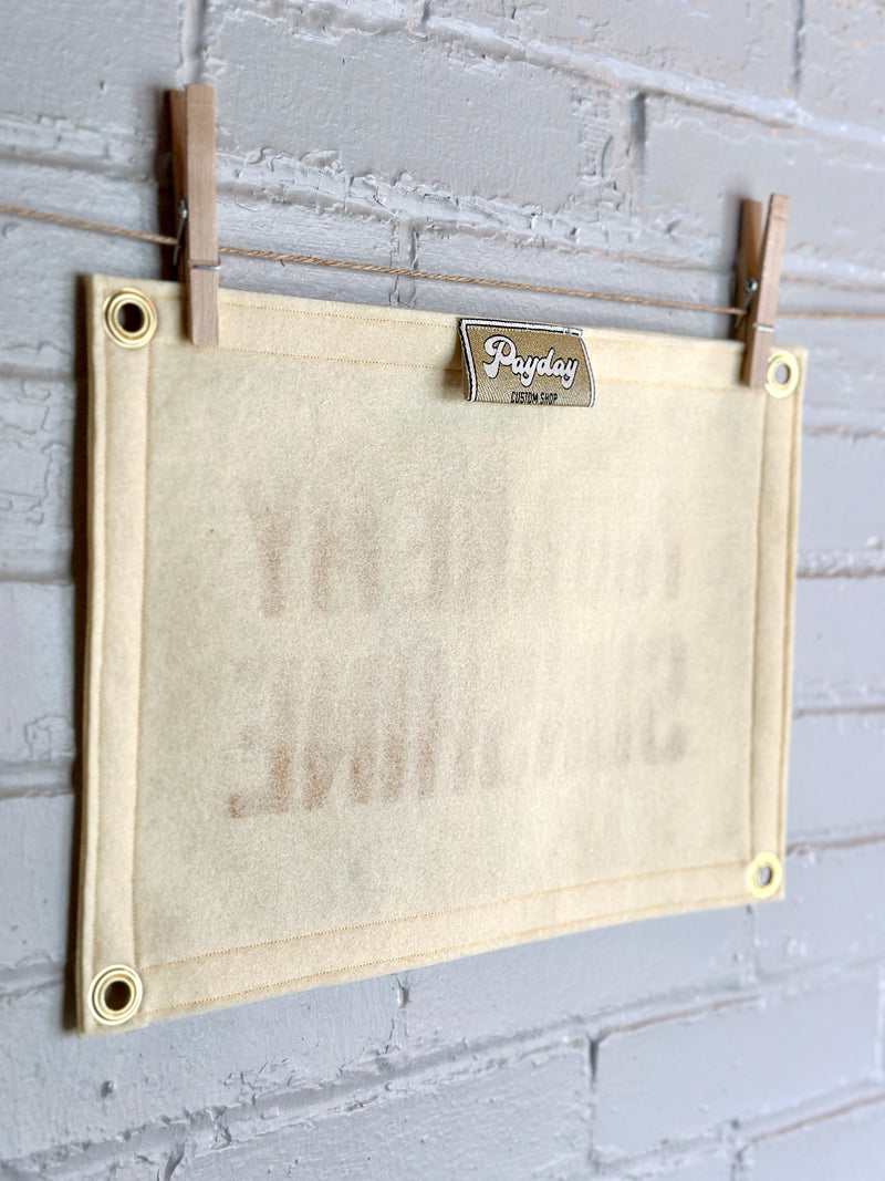 The back of a cream banner with golden Payday Custom Shop tag visible.