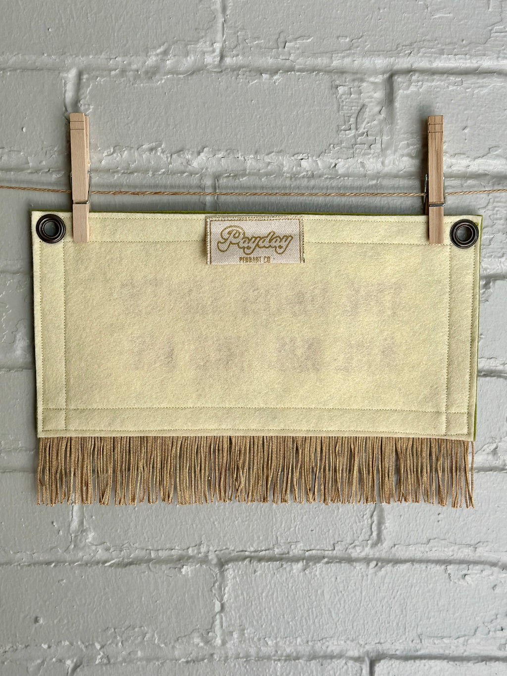 The back of a cream felt banner with gold fringe