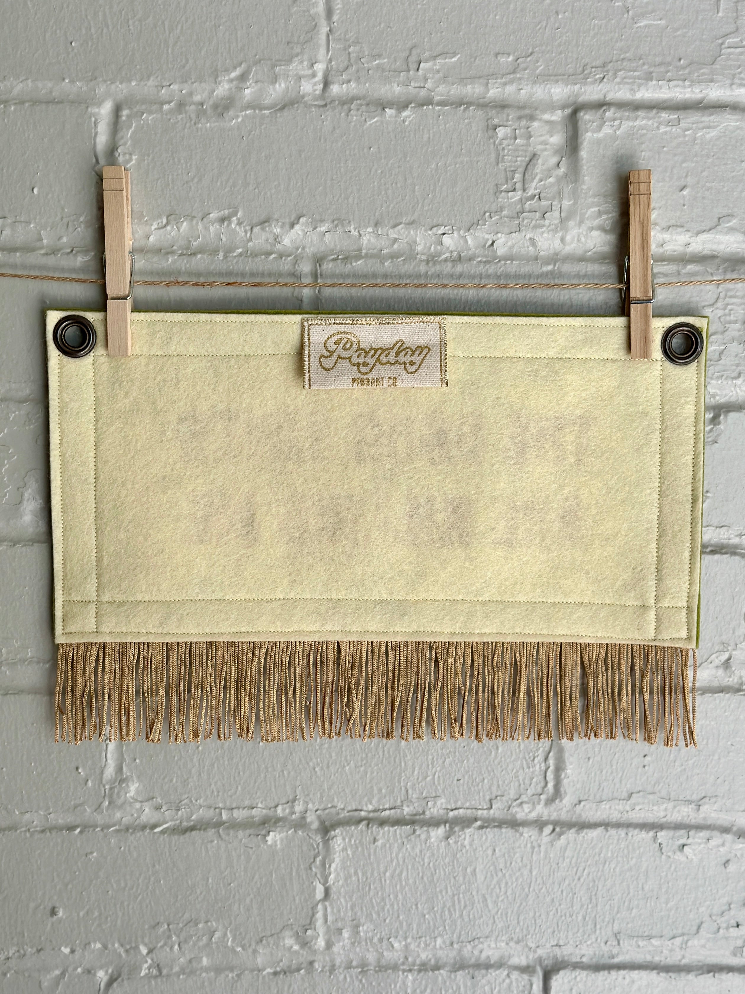 The back of a cream felt banner with gold fringe