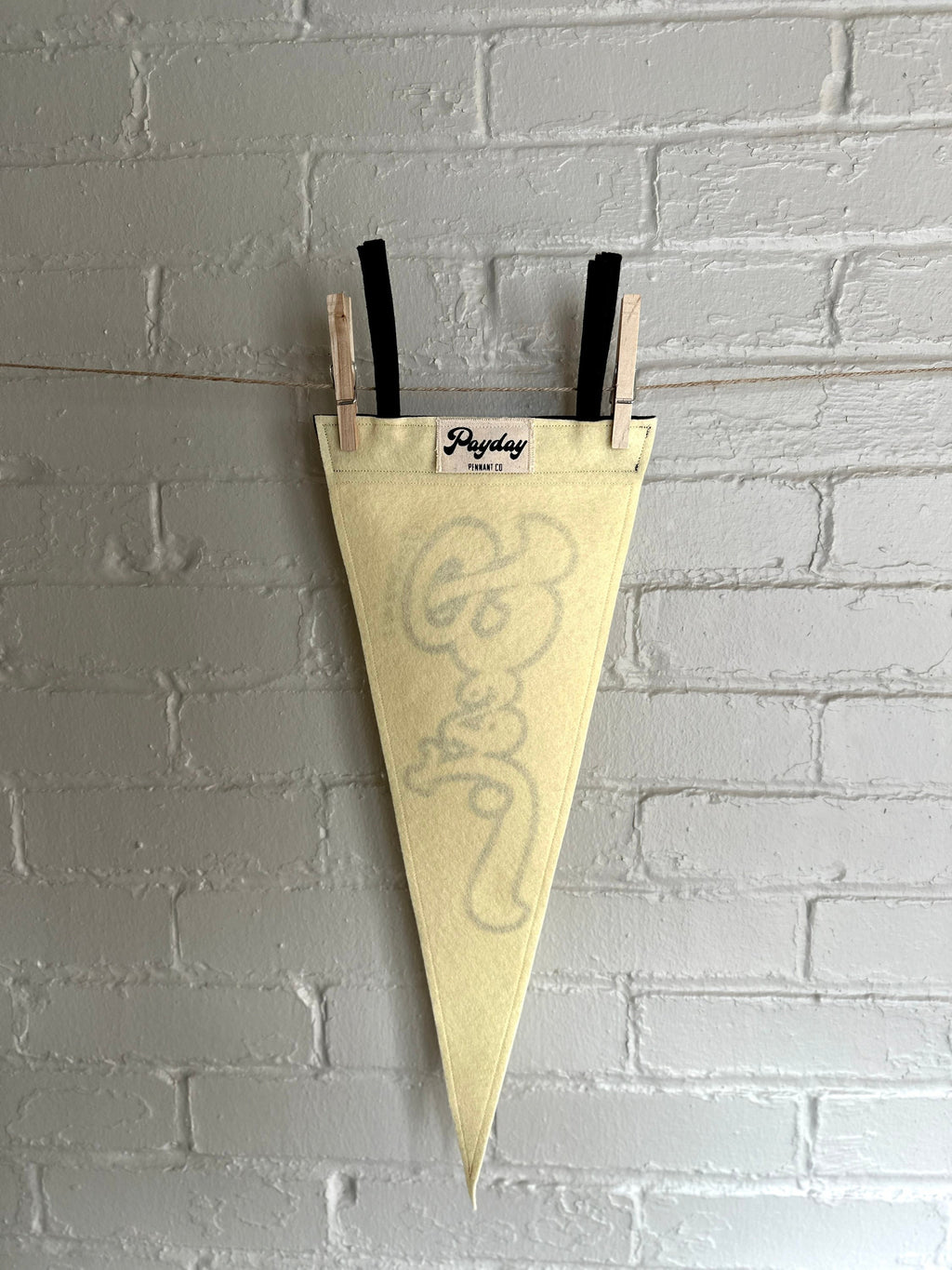 The back of a cream felt pennant with black trim and black lettering that reads "I'm trying my best"