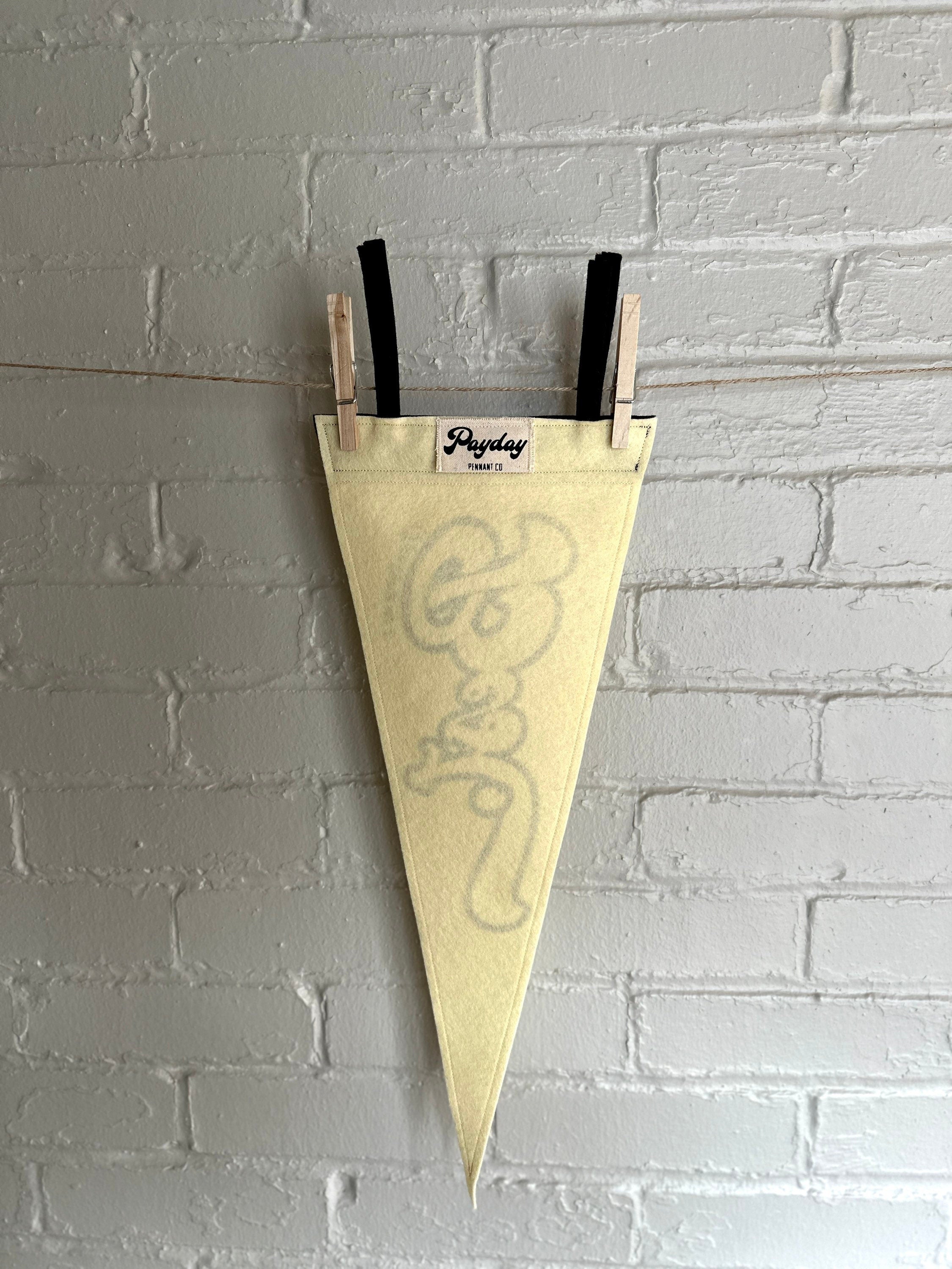 The back of a cream felt pennant with black trim and black lettering that reads "I'm trying my best"
