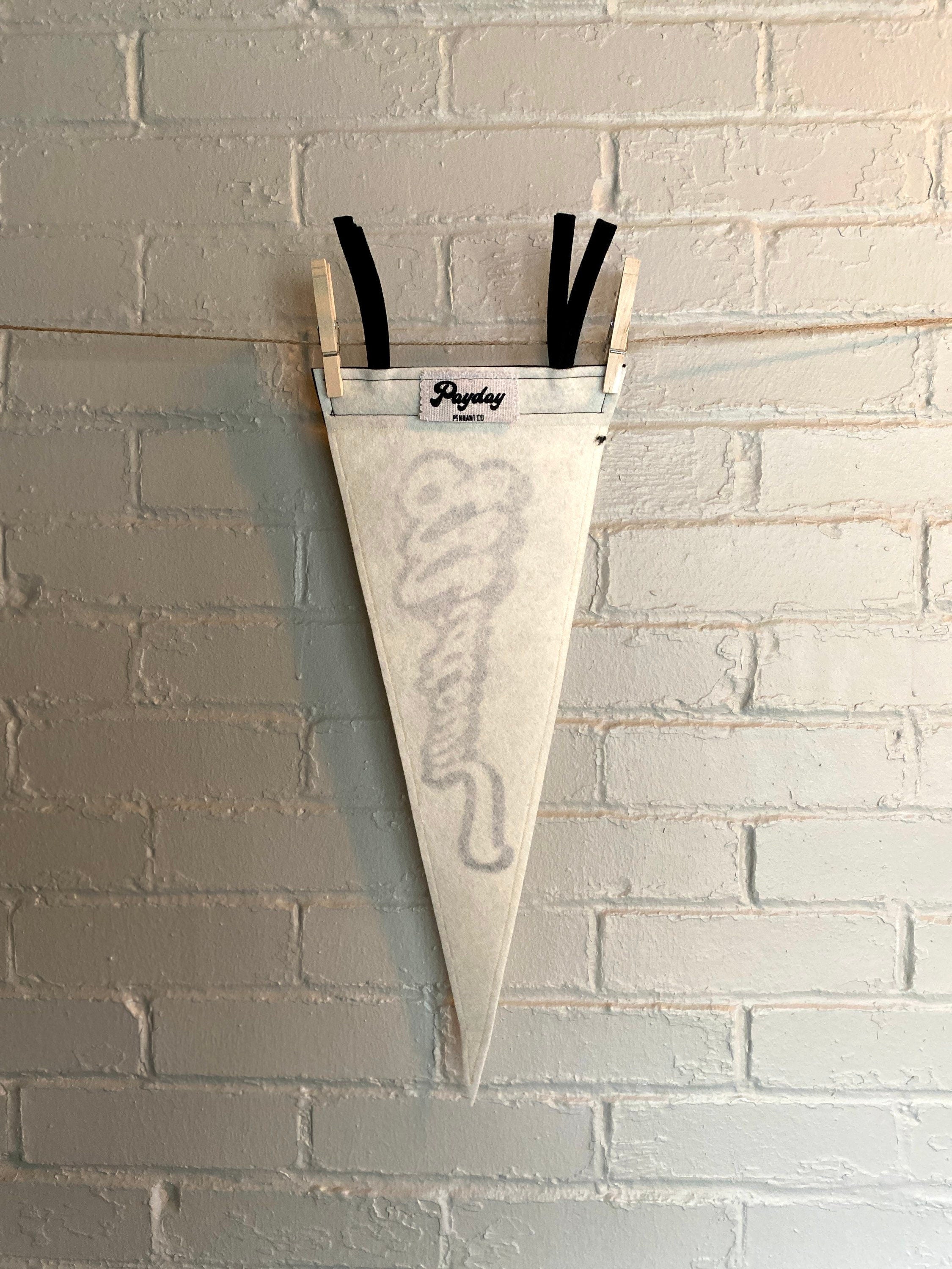 The back of a black and white pennant that reads "Midtown" with the pennant horizontal