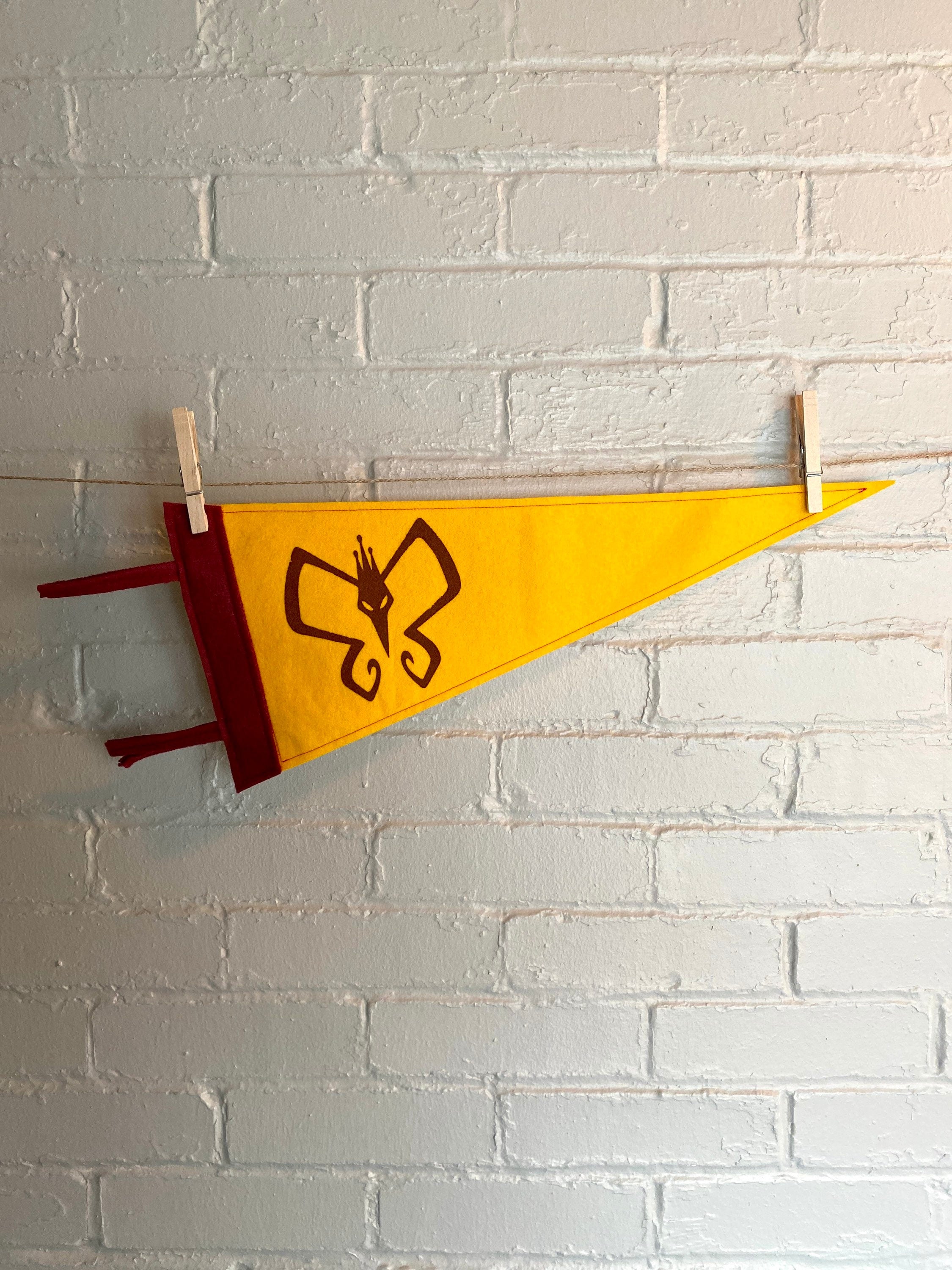 Yellow pennant with burgundy trim and the Monarch's insignia from the Venture Bros printed in burgundy ink