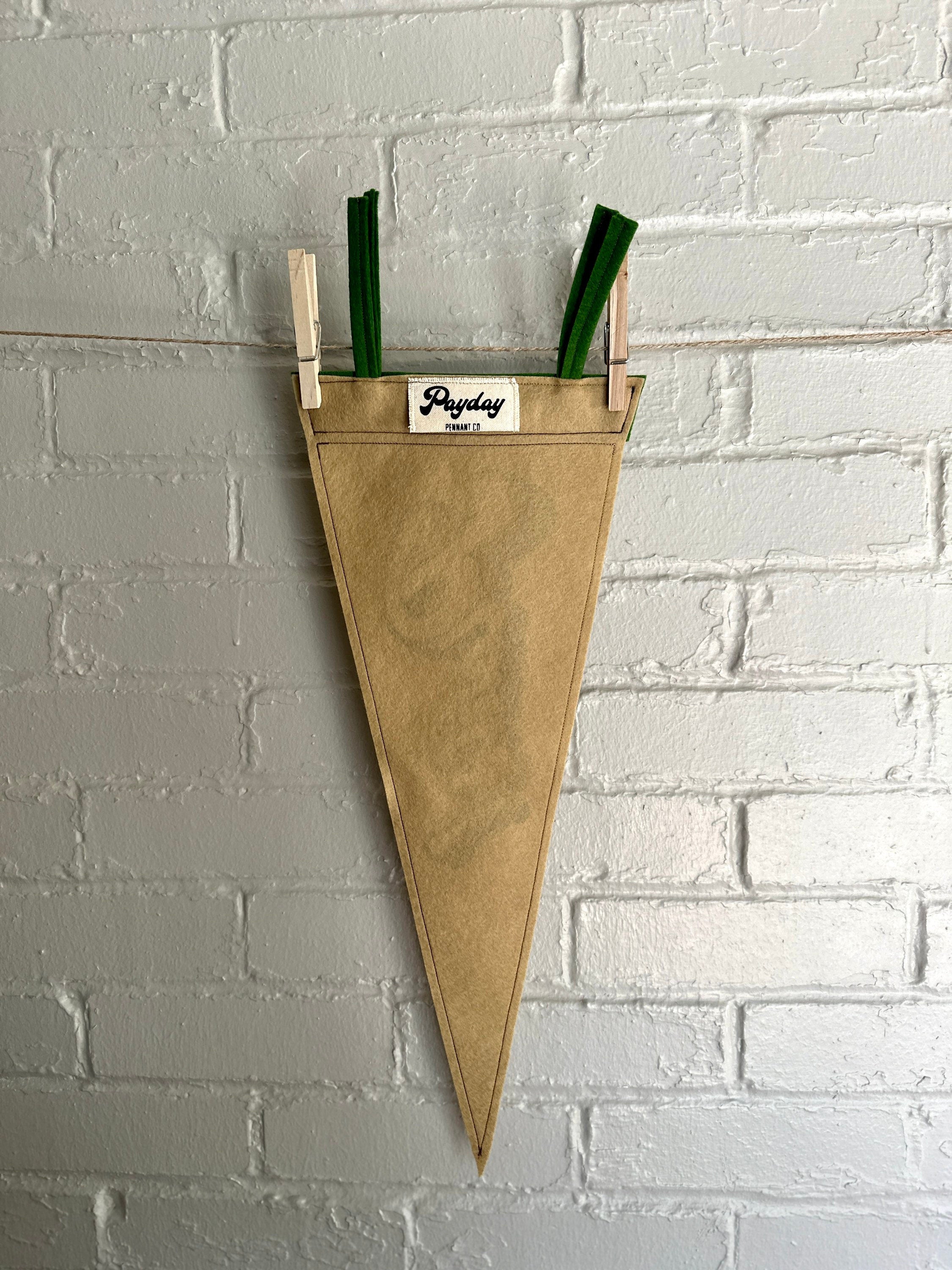 Back of a light brown felt pennant with green trim and green lettering that reads "Plants!"