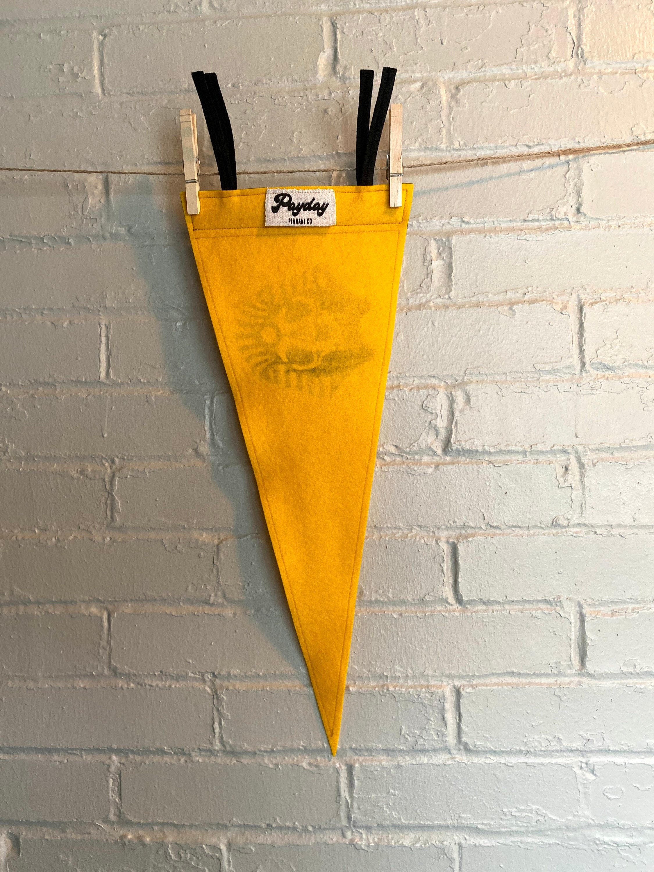 Back of a yellow felt pennant with black trim and the SPHINX logo from The Venture Bros cartoon printed in black ink