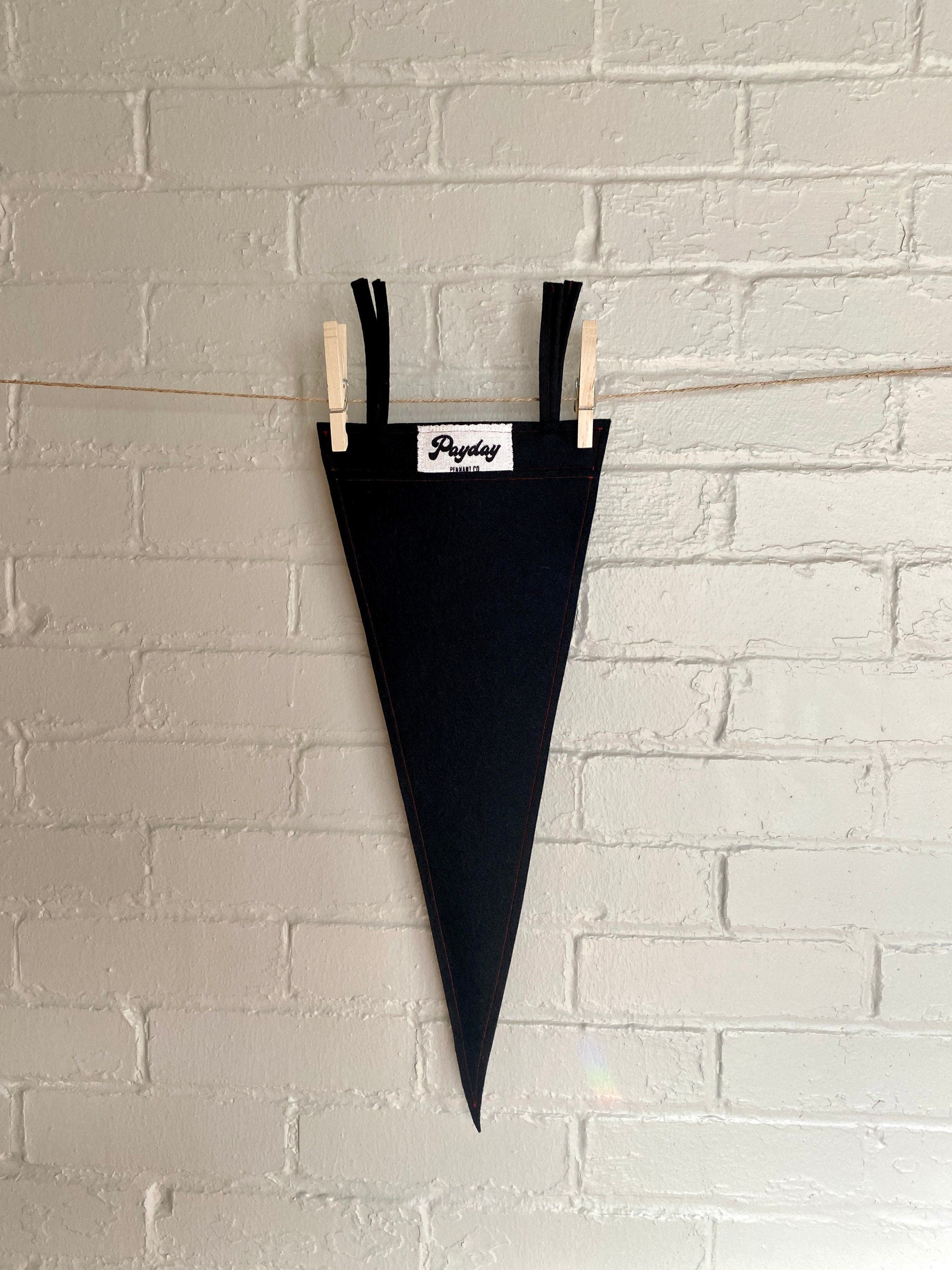 Back of a black felt pennant with black trim and the Order of the Triad logo from The Venture Bros cartoon printed in red ink